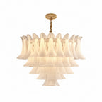 Luxurious chandelier hanging in a bright room with white walls and large windows.
